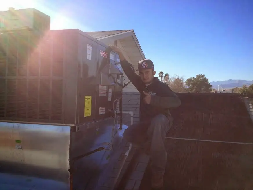 HVAC technician performing AC Tune-Up on a rooftop unit in Avocado Heights